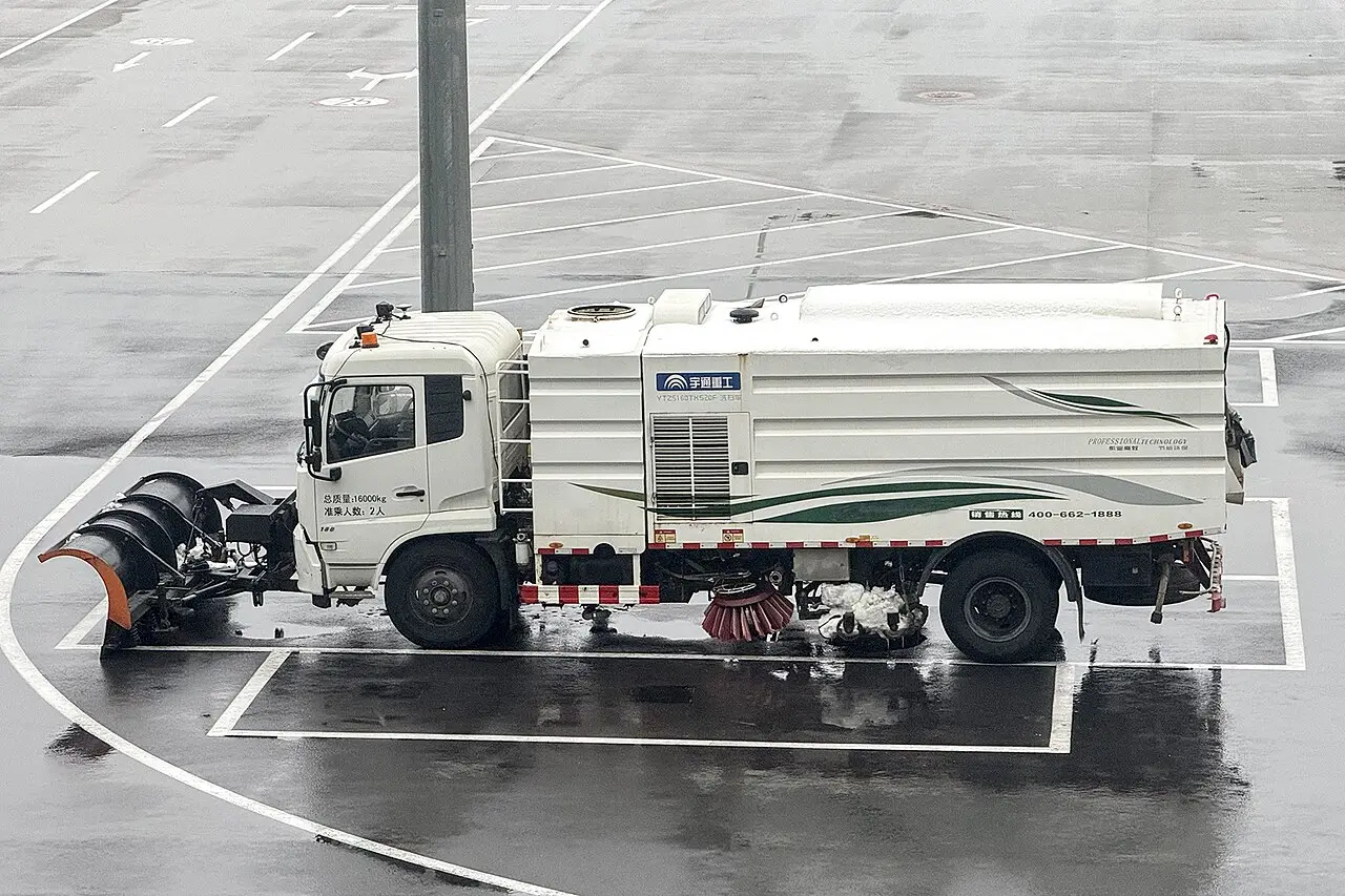 Plow truck clearing a commercial parking area, illustrating retail storm prep in Middletown